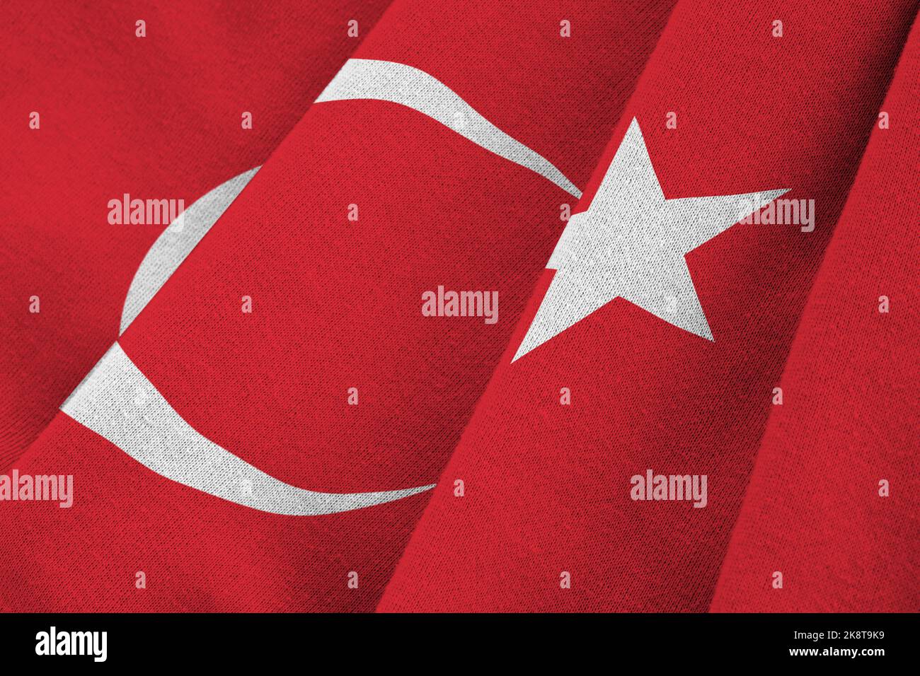 Turkey flag with big folds waving close up under the studio light indoors. The official symbols and colors in fabric banner Stock Photo