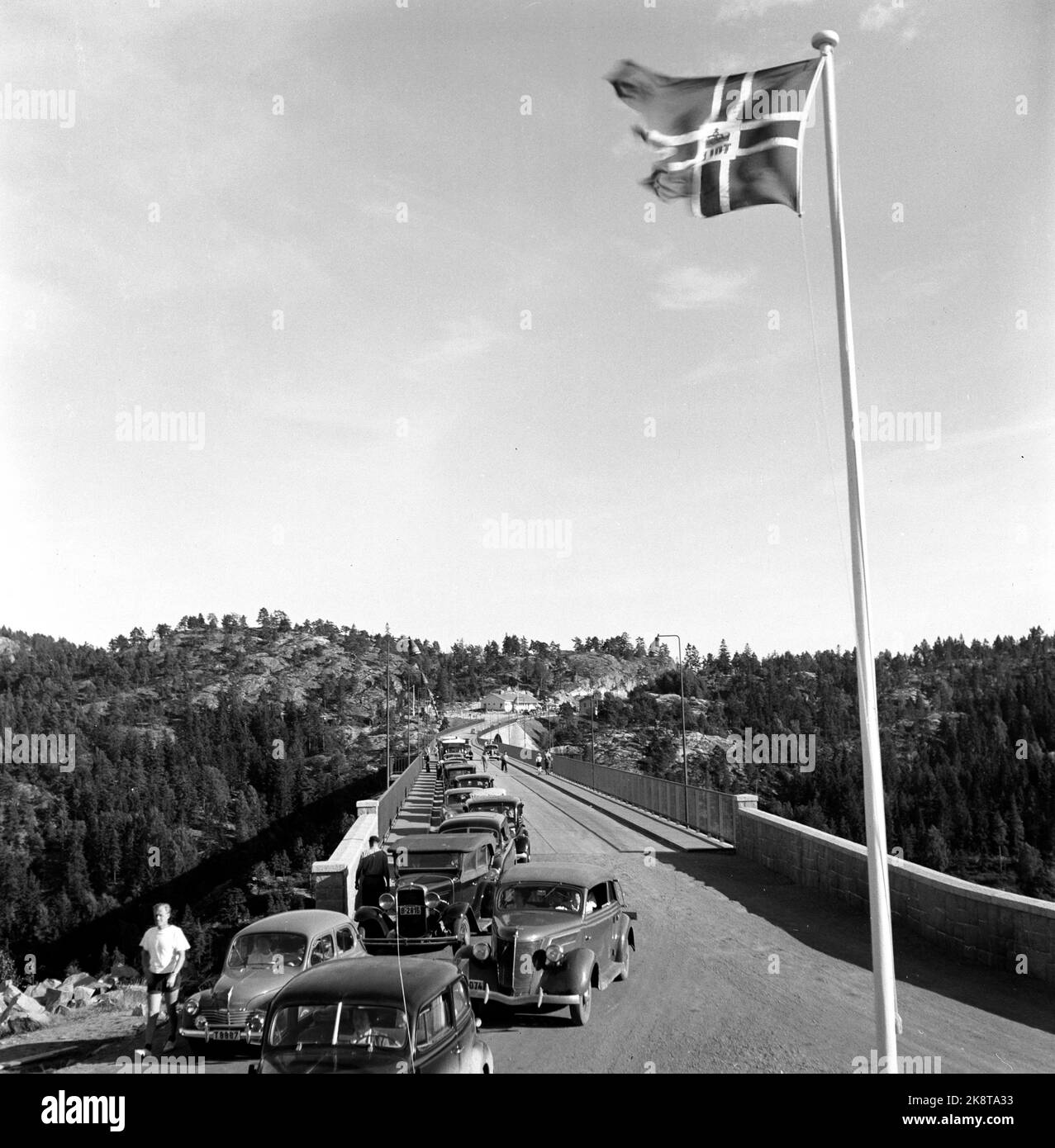 Svinesund 1952; Sugar fever! Norwegians have never crossed the creek for water, but often over the keel for other goods. In the post -war period, sugar was a long -awaited good as there was rationing until 1952. When it was allowed to import 10 kilos of sugar per traveler, the border trade exploded. Norwegian motorists filled the car with '' sugar kids '' who were worth their weight in, if not gold, so at least in sugar! Flag at the customs station at Svinesund. And the car queue is ... infinitely long! Photo; Sverre A. Børretzen / Current / NTB Stock Photo