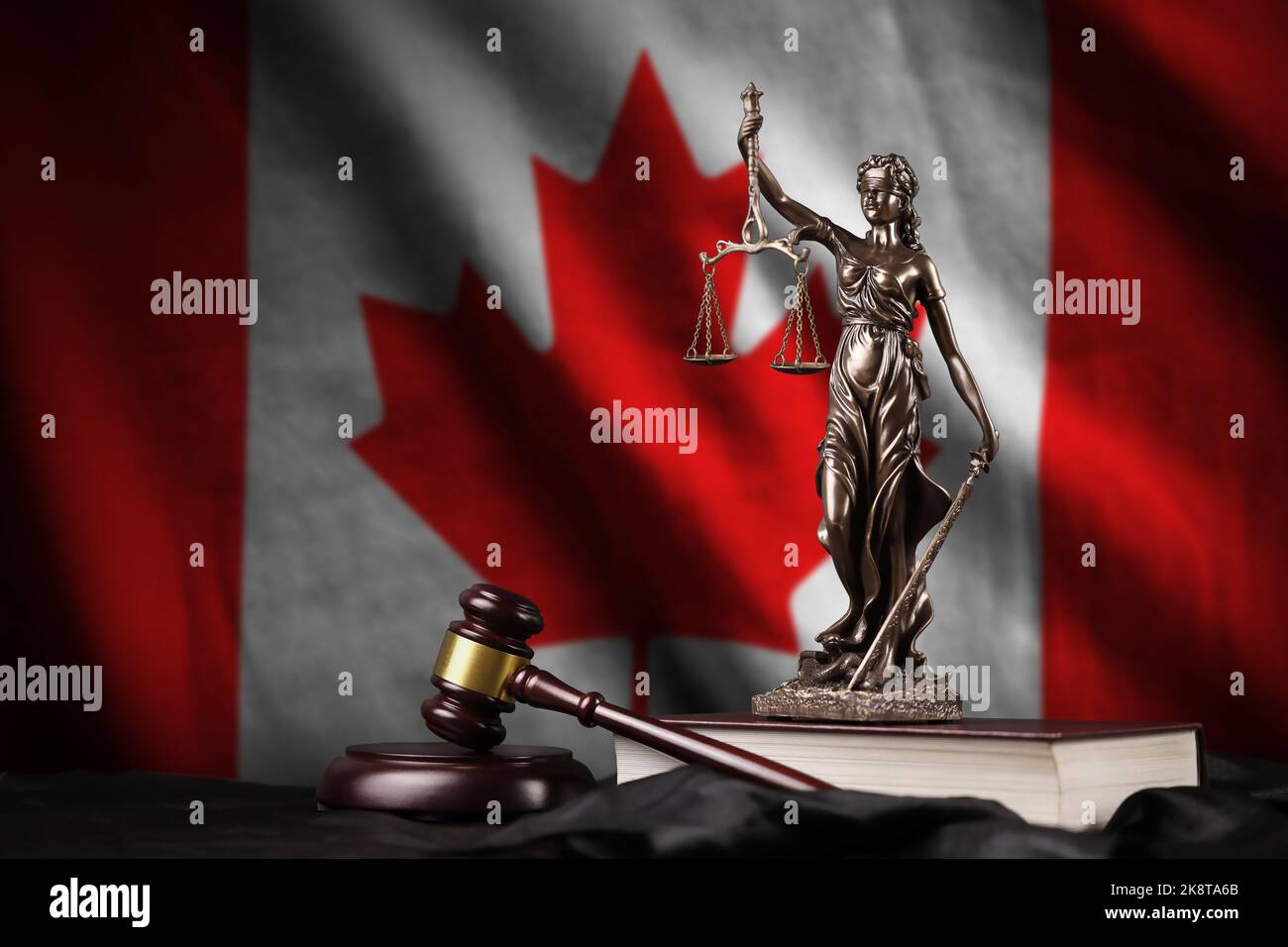 Canada flag with statue of lady justice, constitution and judge hammer