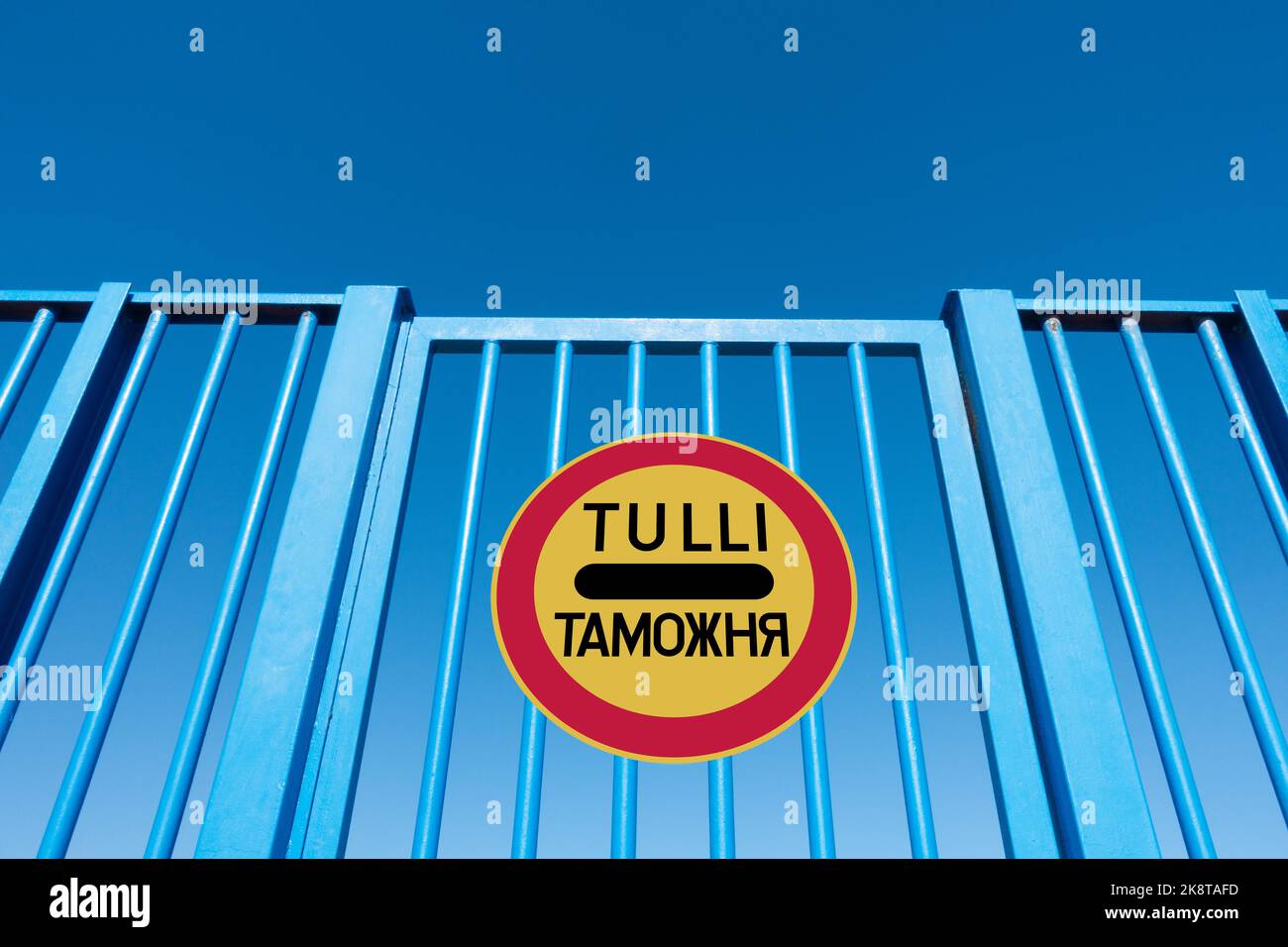 Finland Russia border fence concept image with customs sign in Finnish ( Tulli ) and Russian language. Stock Photo