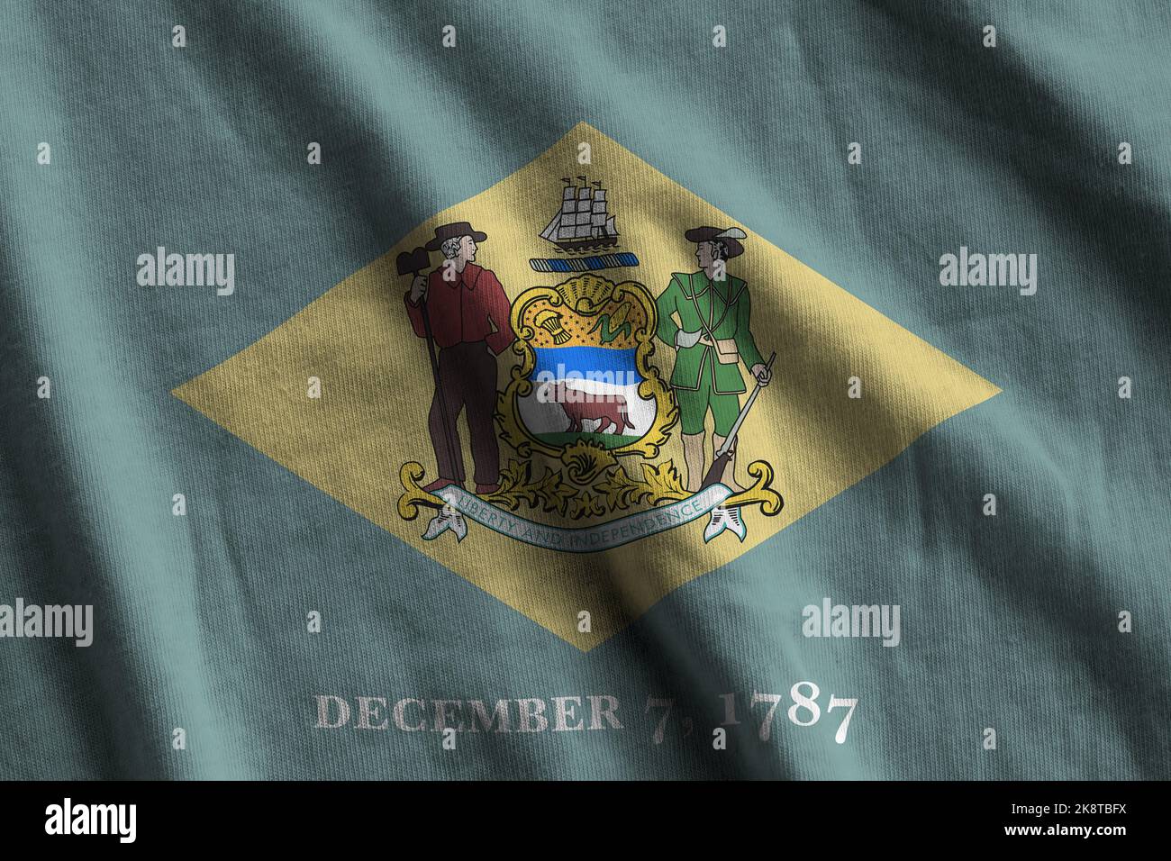 Delaware US state flag with big folds waving close up under the studio light indoors. The official symbols and colors in fabric banner Stock Photo