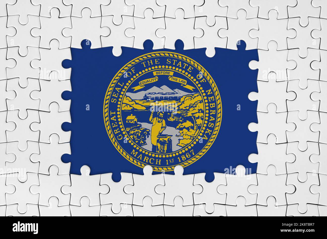 Nebraska US state flag in frame of white puzzle pieces with missing central parts Stock Photo