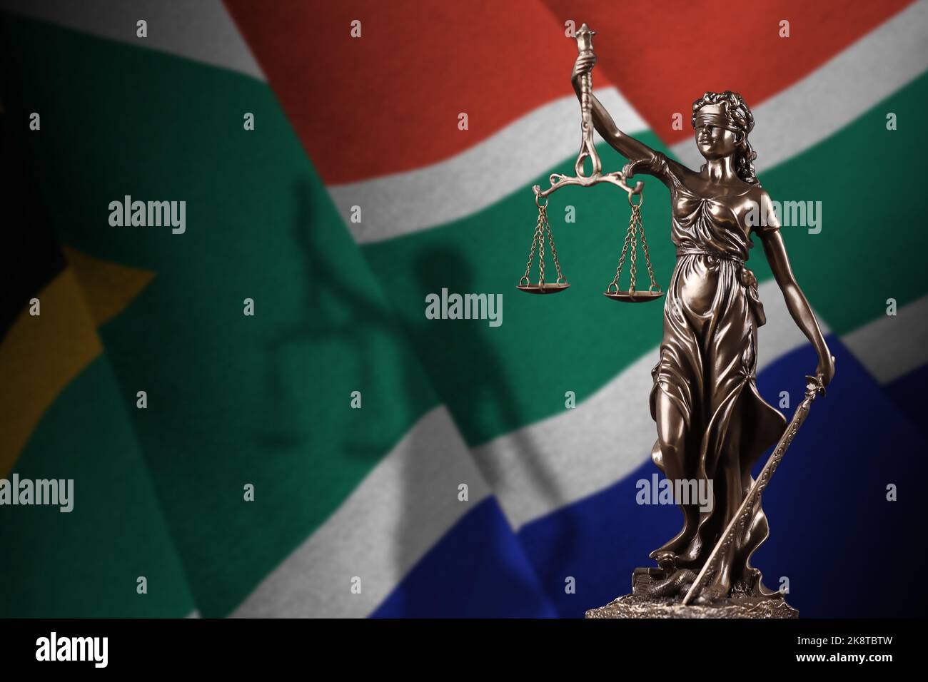 South Africa flag with statue of lady justice and judicial scales in
