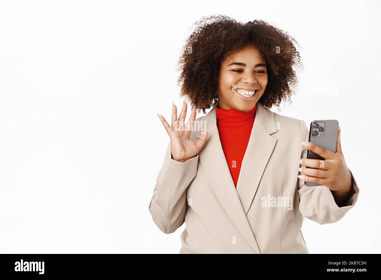Smiling african american businesswoman video calling, waving hand at ...