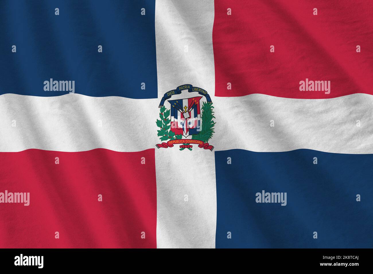 Dominican Republic flag with big folds waving close up under the studio light indoors. The official symbols and colors in fabric banner Stock Photo