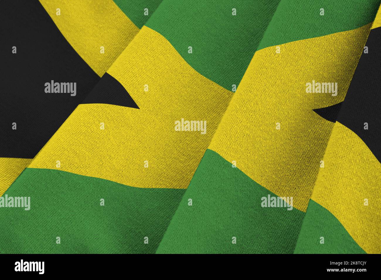 Jamaica flag with big folds waving close up under the studio light