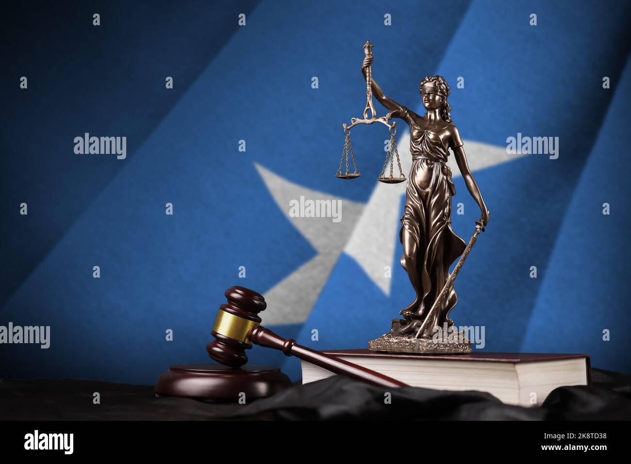 Somalia flag with statue of lady justice, constitution and judge hammer on black drapery. Concept of judgement and punishment Stock Photo