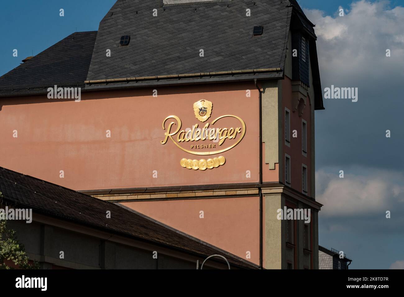 Logo of the Radeberger Pilsner beer on a building exterior. The famous brewery in saxony produces beverages. Golden letters as noticeable advertising. Stock Photo