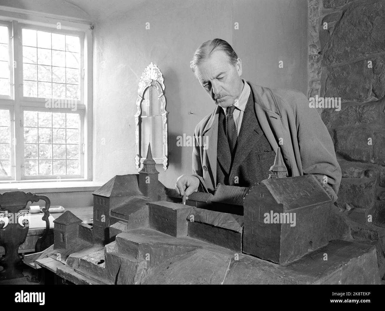 Oslo 195012. Architect Arnstein Arneberg has received the honorable assignments as an interior architect by the Security Council's meeting room in the UN. The Ministry of Foreign Affairs has allocated money for the work that is a gift from Norway. Arneberg in front of the model of Akershus castle that he led the restoration of. Photo: Current / NTB Stock Photo