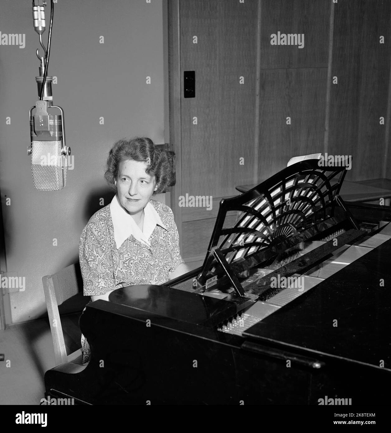 Oslo19530701: Program manager for Children's Hour Else Wildhagen, here at the grand piano. Microphone hangs in the foreground. Photo NTB / NTB Stock Photo