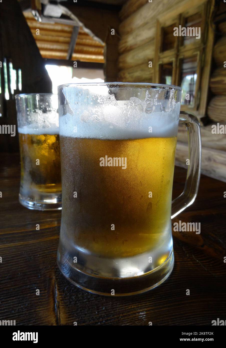 Full glasses of light beer on the wooden table at country beer pub Stock Photo