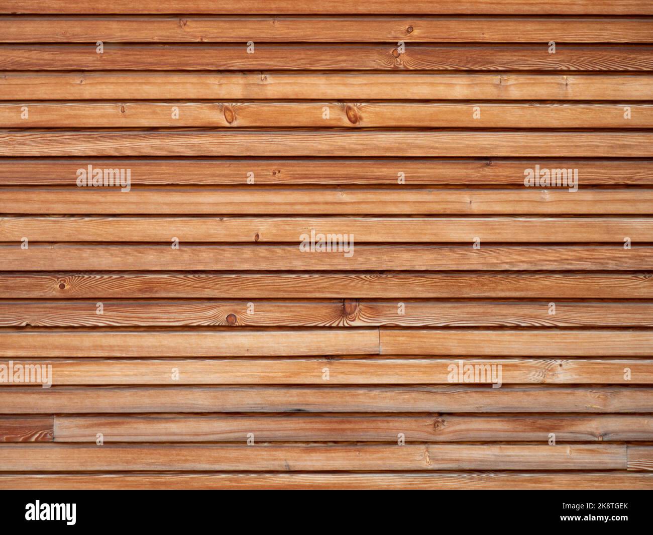 Wooden planks background texture. Timber boards in brown color with woodgrain structure. The design pattern is horizontal on a facade wall. Stock Photo