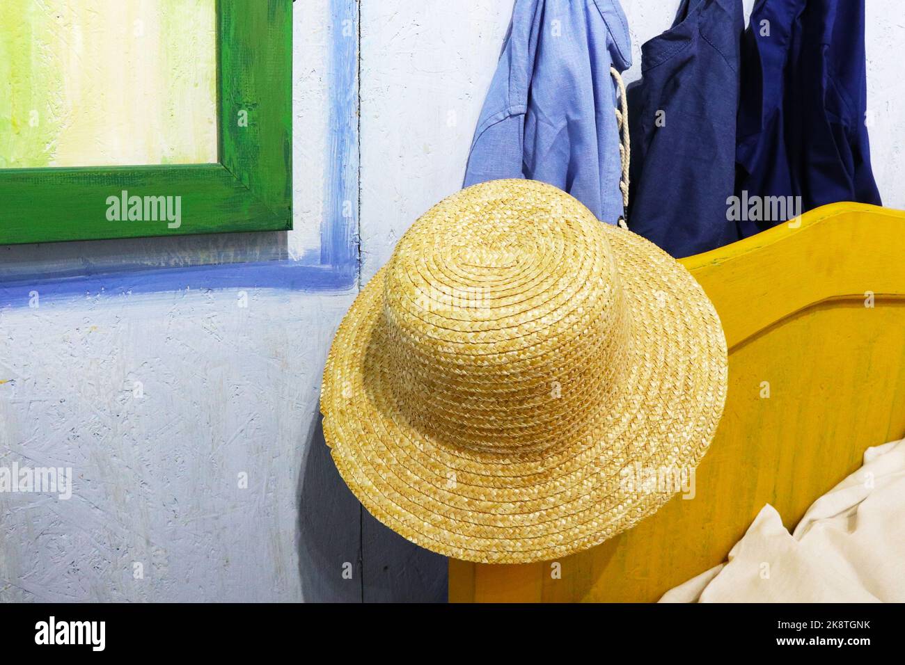 a straw hat is hanging on the bed Stock Photo