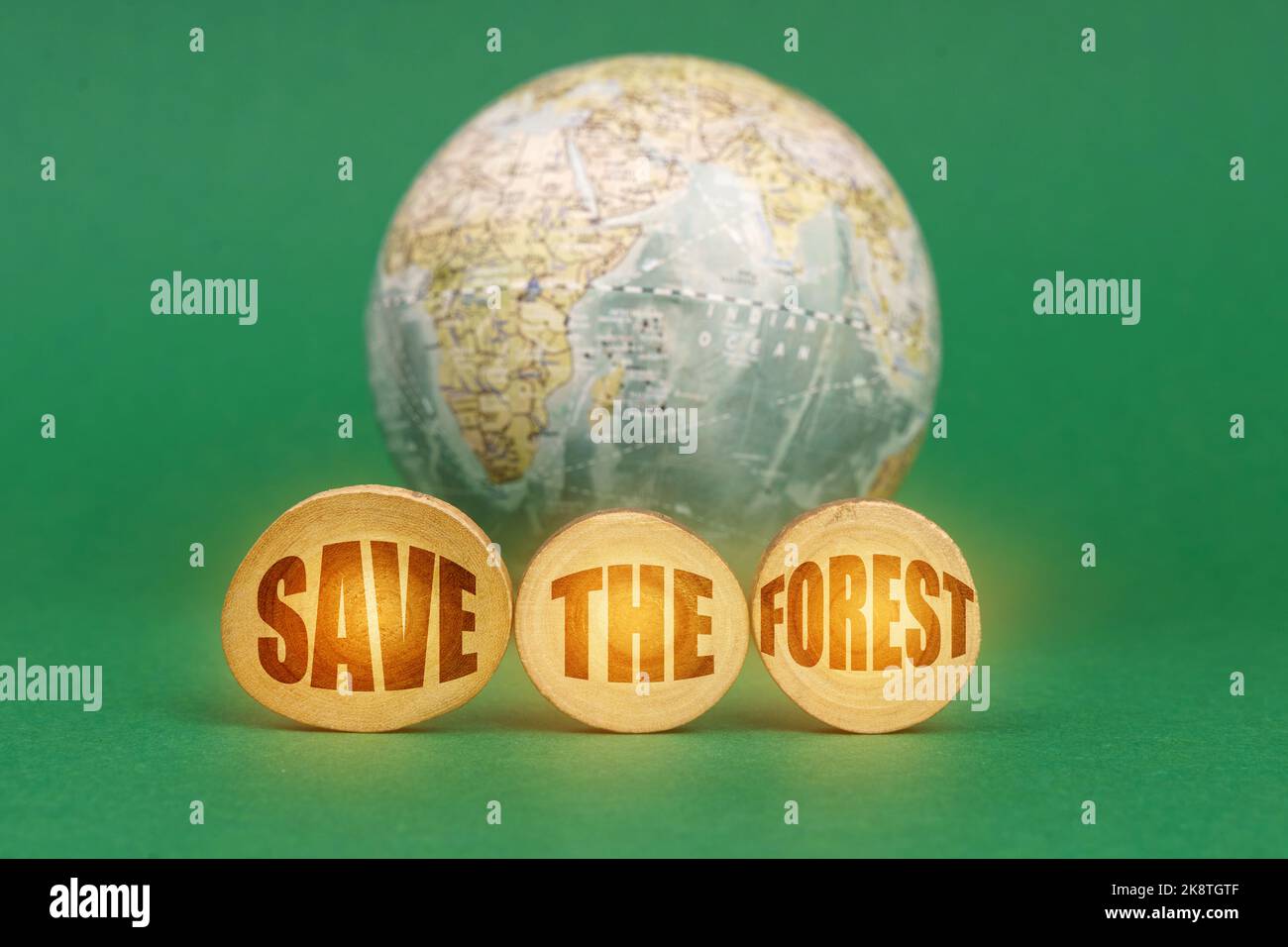 Ecological concept. On a green background, a globe and wooden circles ...