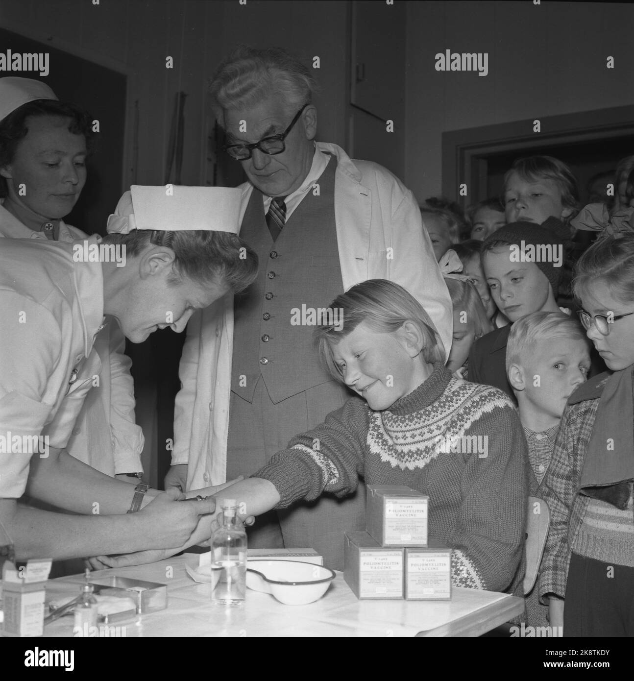 Nes at Romerike, 19561016: The first vaccination against poliomylitis started at Framtun school at Nes at Romerike. Health sister Ruth Hauge vaccinates. District physician Øverland is included. Photo: NTB / NTB Stock Photo