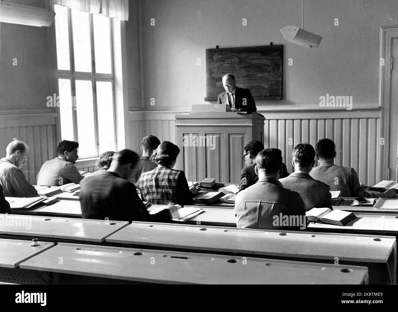 Oslo 1953; The report provides insight into the church battle around the private 'university' Faculty of the Church with sulfur preacher and Professor Dr. Philos. Ole Hallesby at the forefront of the Libereal Bishop Dr. Theol. Kristian Schjelderup. The pictures are from the Faculty of the Church in St. Olavsgate 29. The students have gathered under the lecturer (in the New Testament), Sverre Aalen's catheter. A female student among men. MF was against female priests. Women could only work as a hospital priests, not in churches. The auditorium is spartan equipped. Theology. Photo: Current / NTB Stock Photo