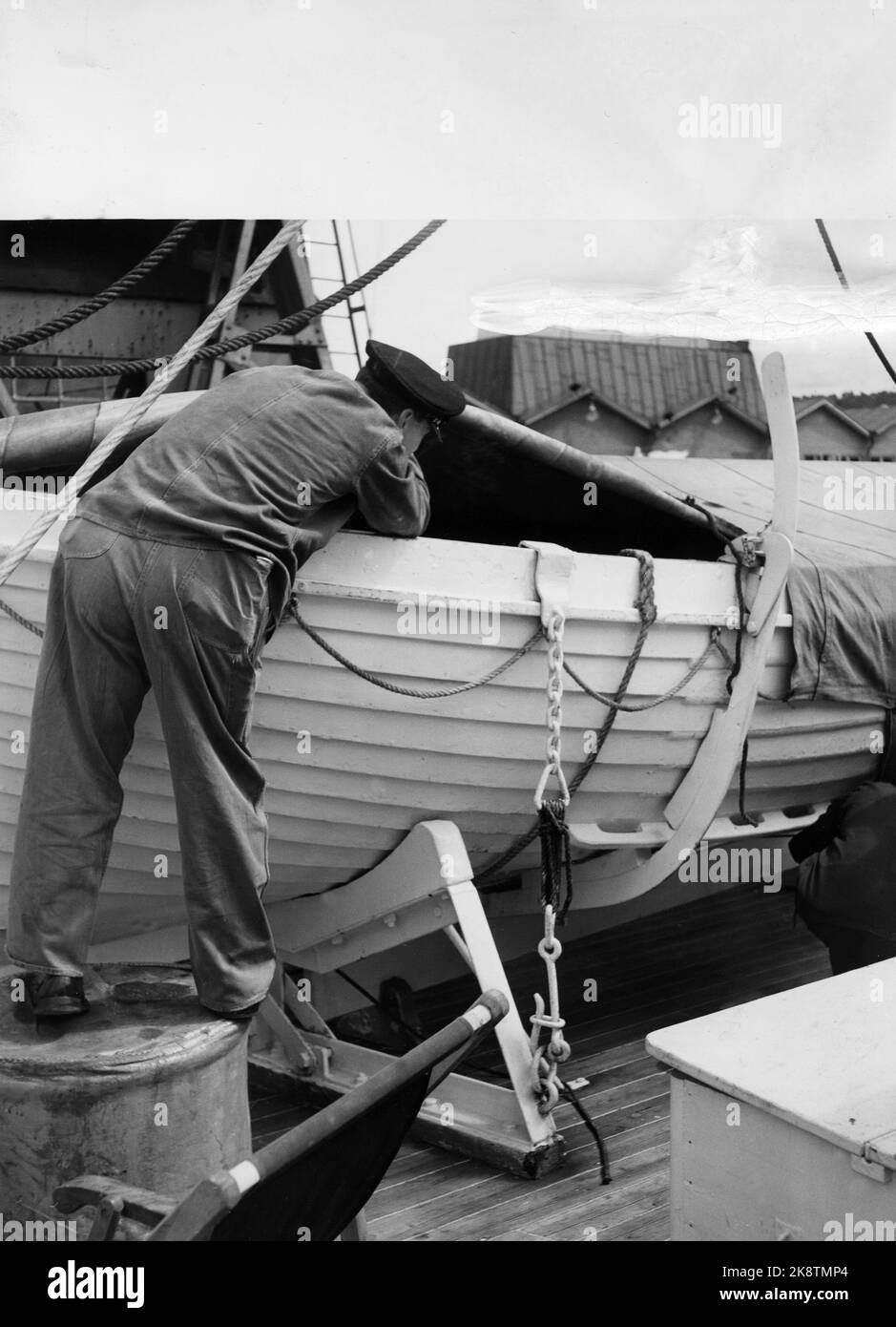 Oslo 1957. The Customs Service at work at the Port of Oslo. Tollers are looking for 'sinners'; IE seafarers who are trying to evade customs. Here the toller is looking for something that can be hidden in the lifeboat of the ship. Photo: Aage Storløkken / Current / NTB Stock Photo