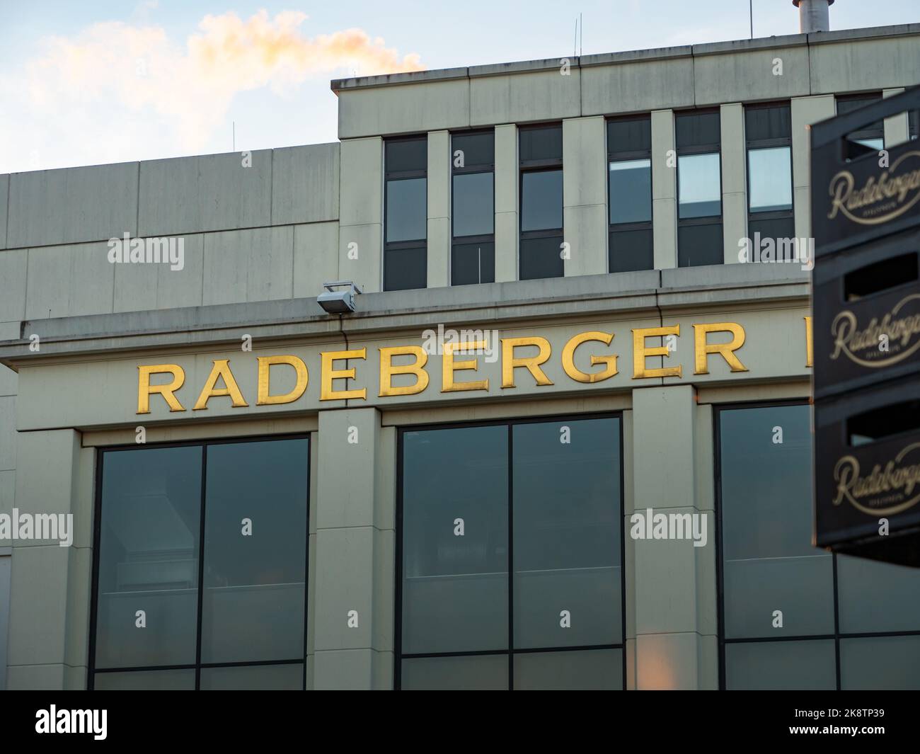 Radeberger lettering of the famous beer brand. Golden letters on the brewery in Saxony. Close-up of the building exterior. Beer crates are visible. Stock Photo