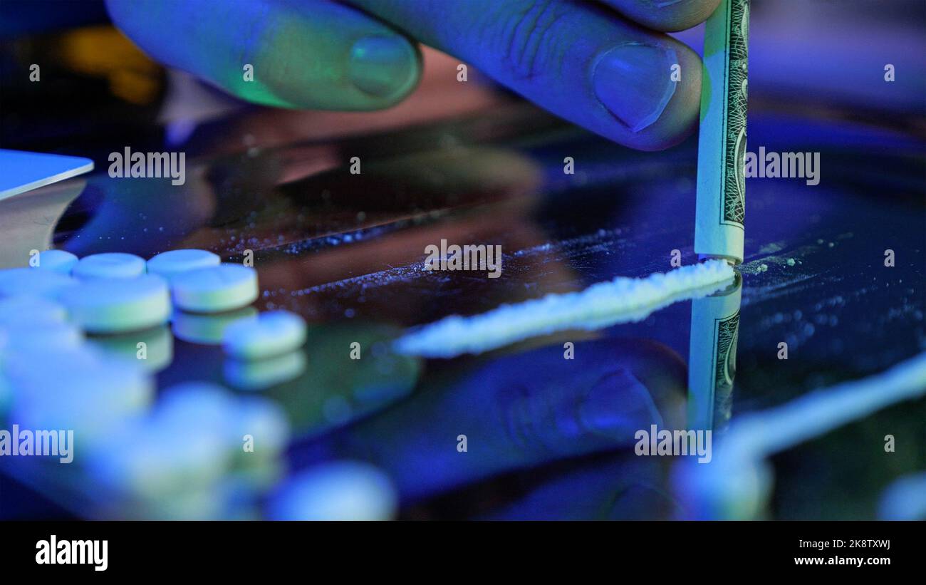Cocaine sniffing. Drug addict concept: hard drugs prepared for consumption. Cocaine, amphetamine, meth, methamphetamine. Silver tray with powder drugs Stock Photo