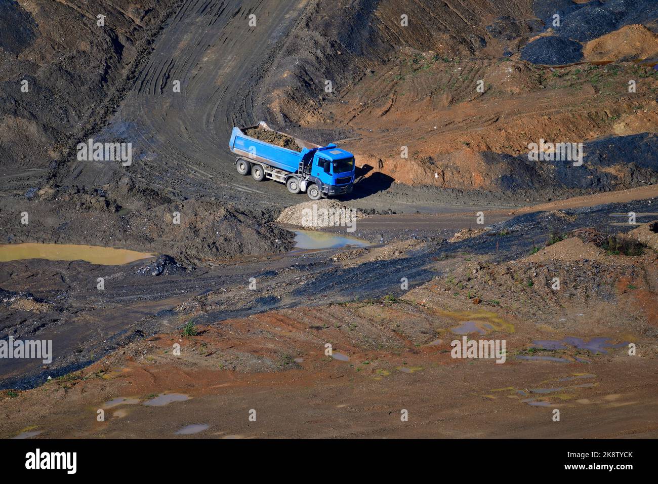 Large trucks transport excavated earth and rocks for highway construction Stock Photo