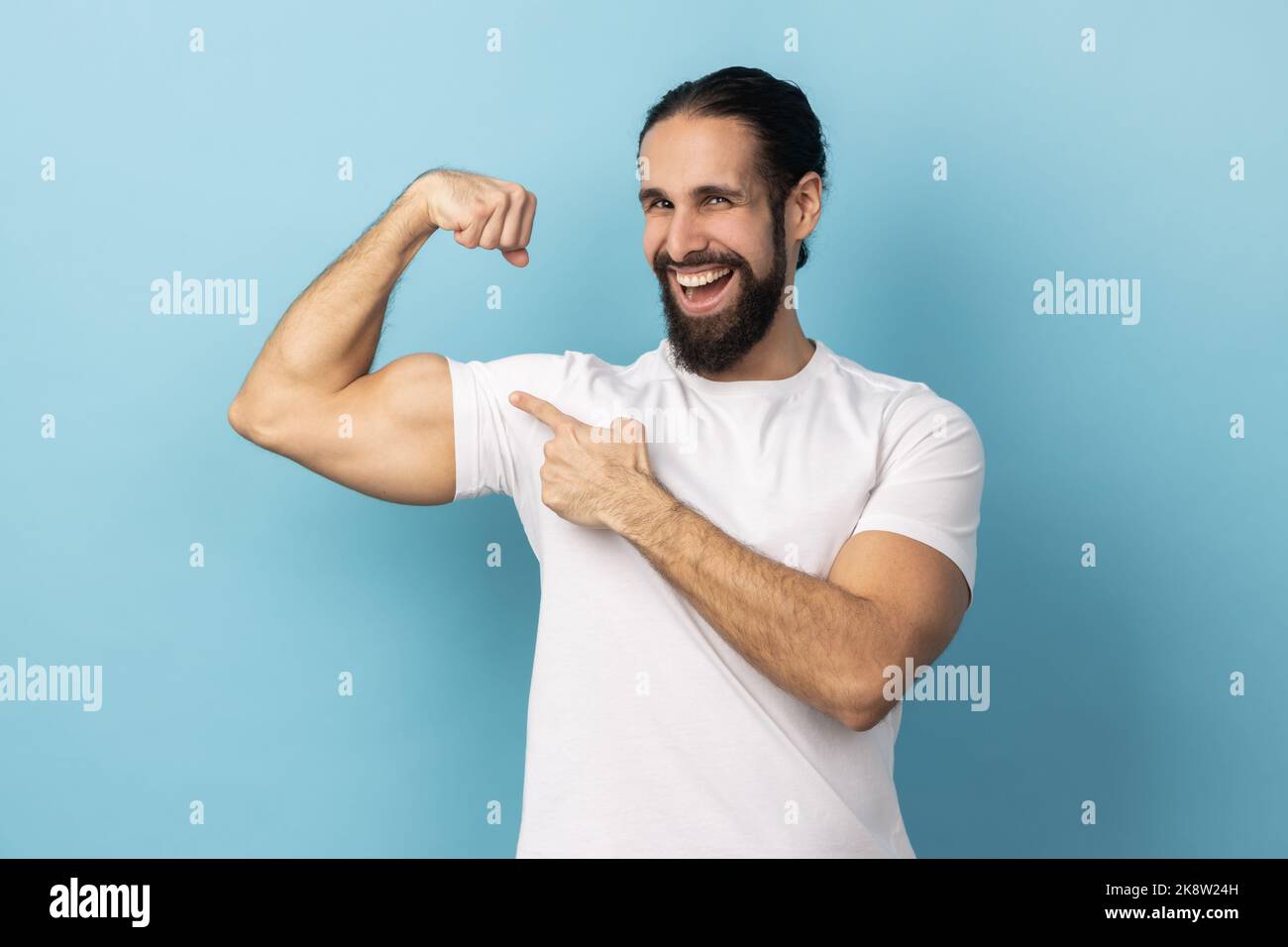 Finger Biceps Man bodybuilder with beard wearing white T-shirt pointing finger at his ...