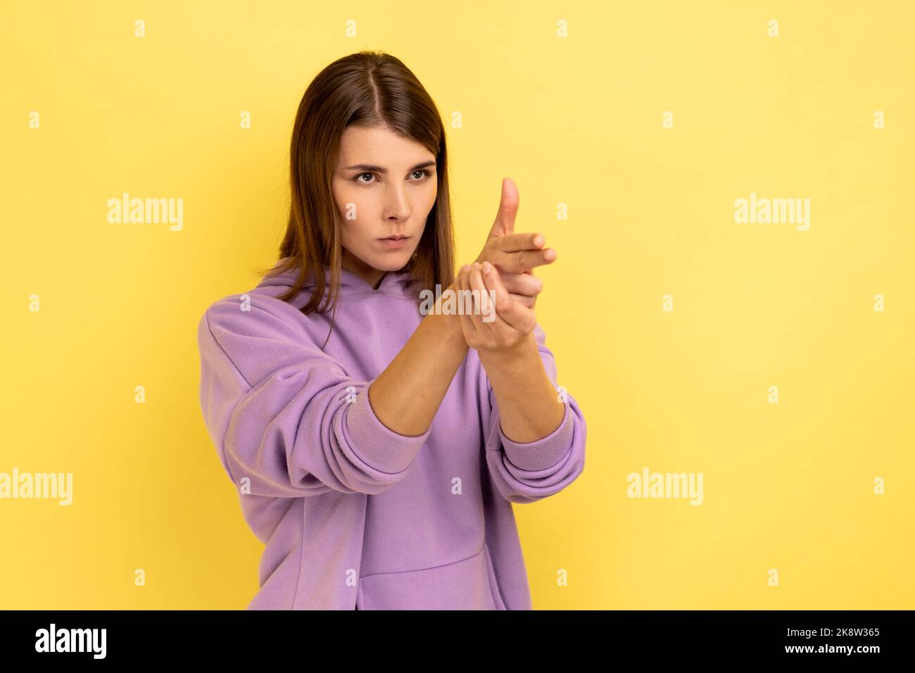 I'll kill you. Portrait of angry woman pointing finger guns to camera