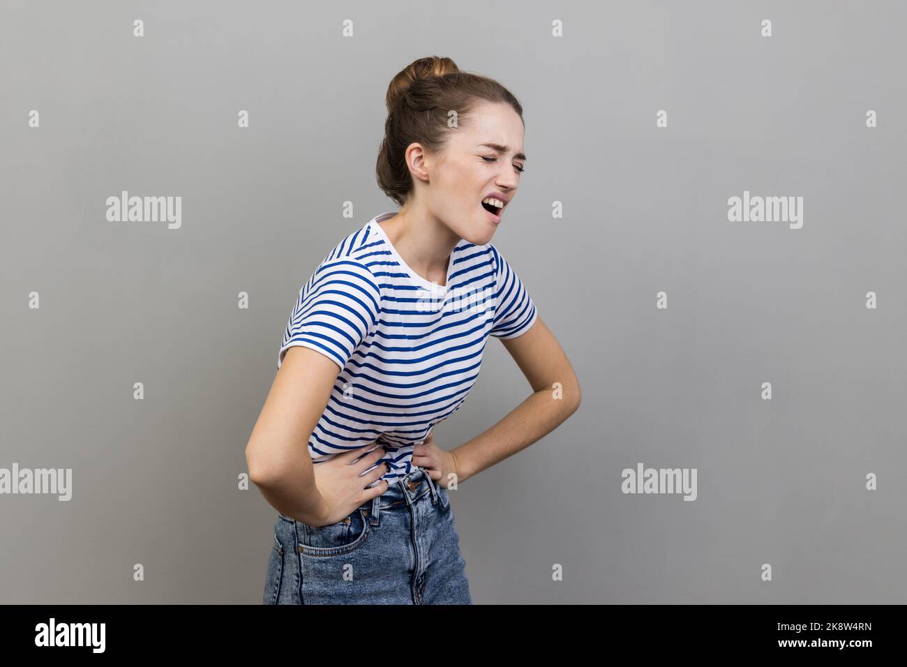 Abdominal pain, periods cramps. Side view portrait of woman wearing