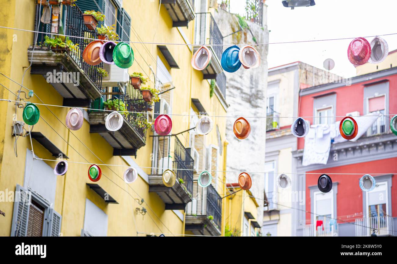 Colourful hats hung between blocks on a wire in Naples Italy Stock Photo