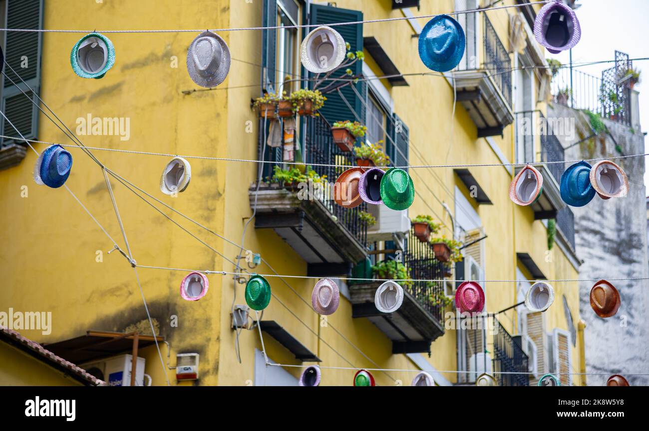 Colourful hats hung between blocks on a wire in Naples Italy Stock Photo
