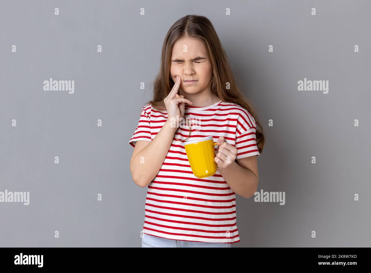 portrait-of-unhealthy-little-girl-wearing-striped-t-shirt-touching-chin