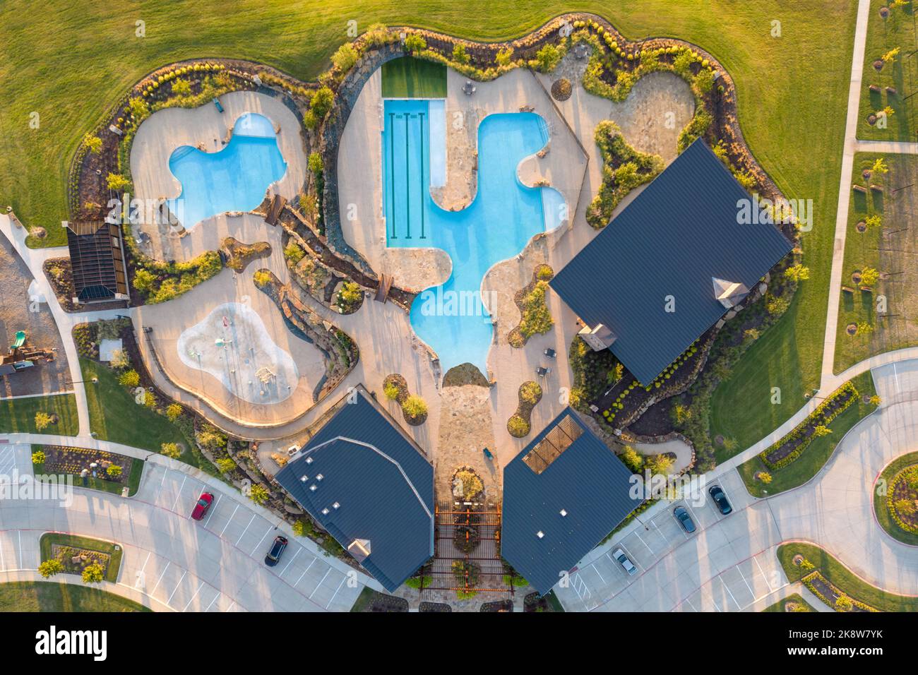 Aerial shot of green lawn, swimming pool, lounge area near beautiful