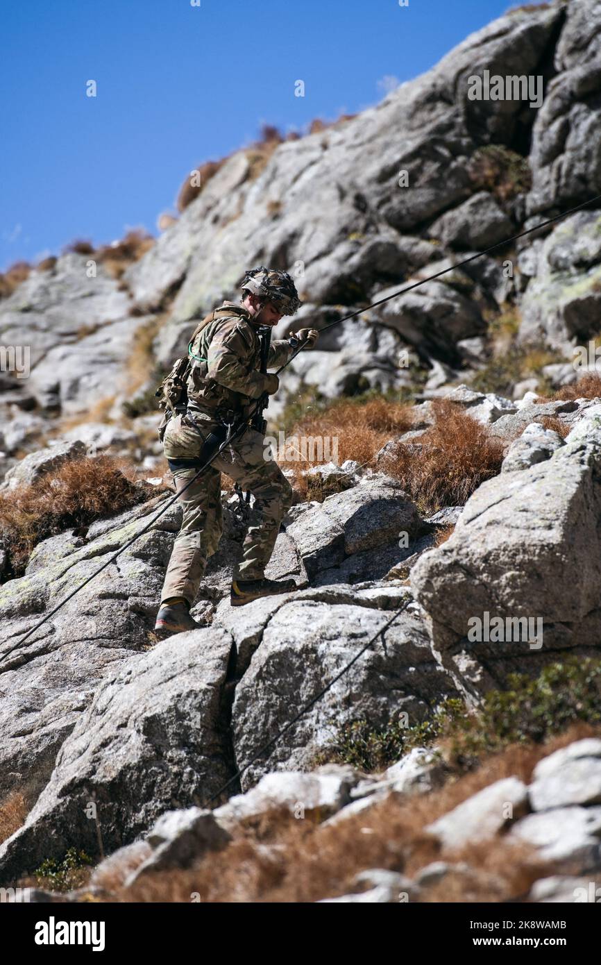 A U.S. Army paratrooper assigned to 2nd Battalion, 503rd Parachute Infantry Regiment repels down a rock face as soldiers with the Italian Army’s Alpini Brigade assault an objective during a blank-fire exercise as part of Exercise Summer Resolve in the Province of Bolzano, Italy, Oct. 3, 2022.    Exercise Alpine Star is an annual Italian Army hosted, multinational and multi-phased mountain and arctic warfare training exercise. Reconnaissance paratroopers from the 173rd Airborne Brigade integrate within select companies of the Italian Army’s Alpini Brigade to learn techniques in traversing, asce Stock Photo