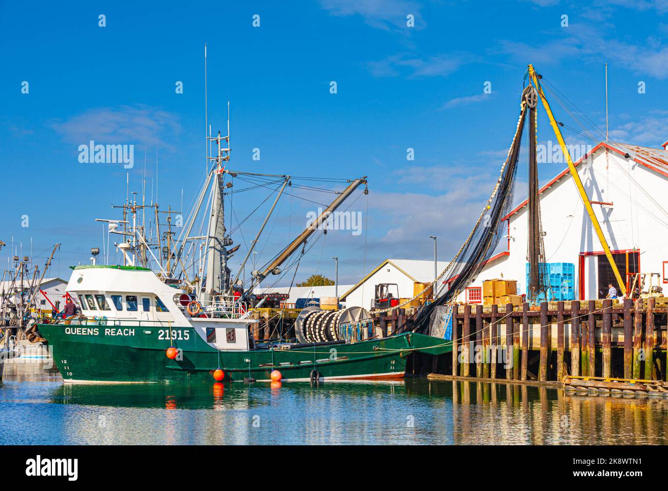 Commercial fishing vessel preparing to unload its net for repair and storage in Steveston Harbour British Columbia Canada Stock Photo