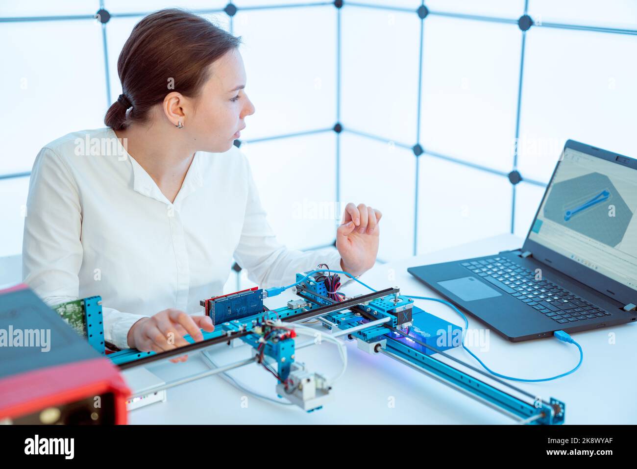 female student sets parameters of CNC laser plotter in university robotics lab Stock Photo