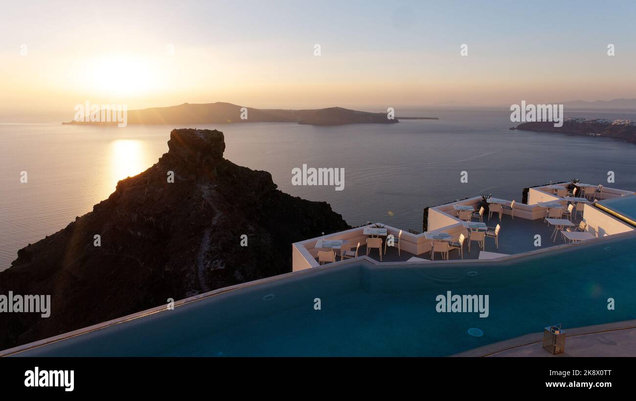 Sun setting over Thirasia with Skaros Rock foreground. Aegean Cyclades Island of Santorini, Greece. Stock Photo