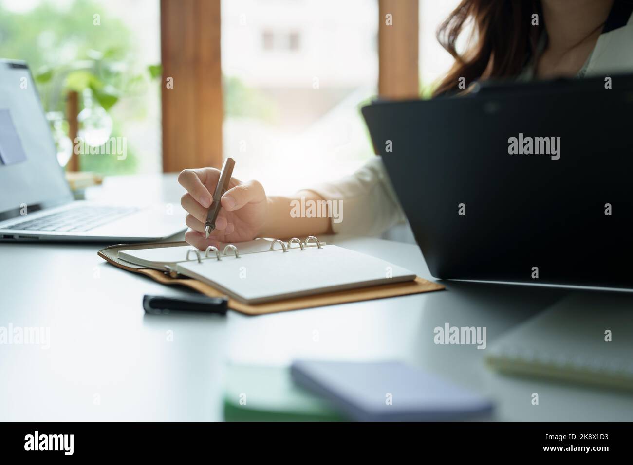 portrait-of-an-asian-bank-employee-using-notebooks-to-take-notes