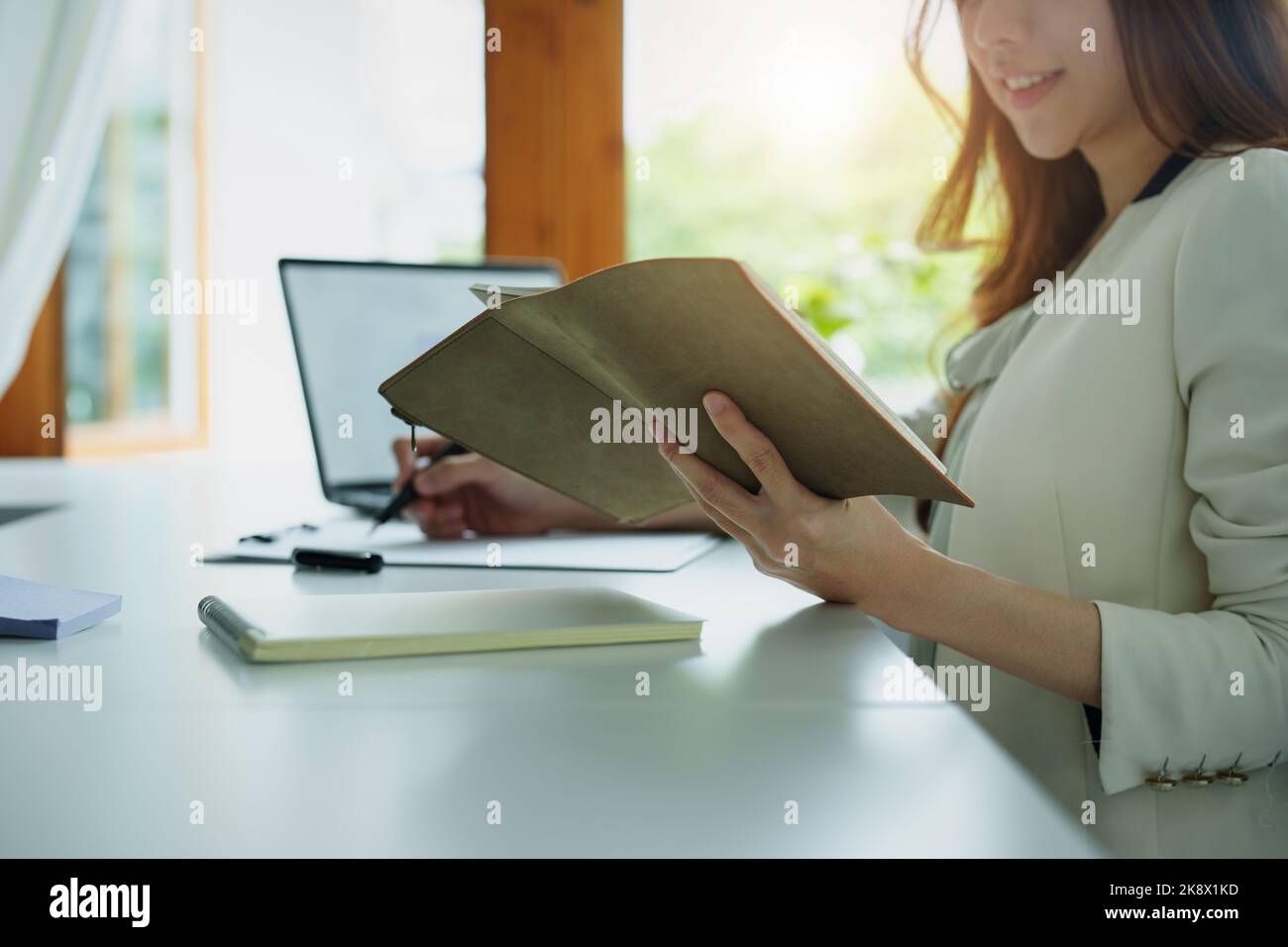 portrait-of-an-asian-bank-employee-using-notebooks-to-take-notes