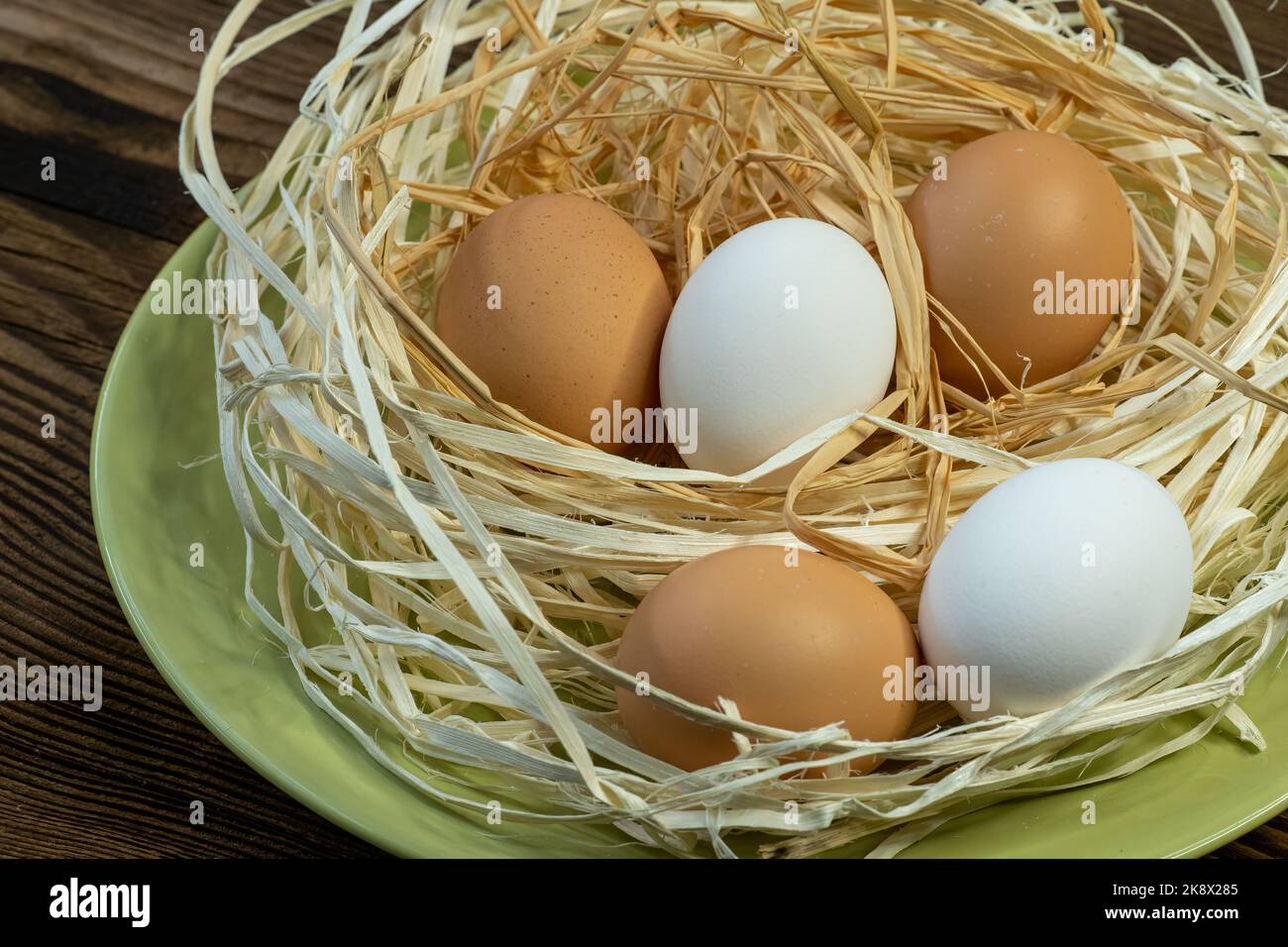 Brown and white eggs in a straw nest Stock Photo - Alamy