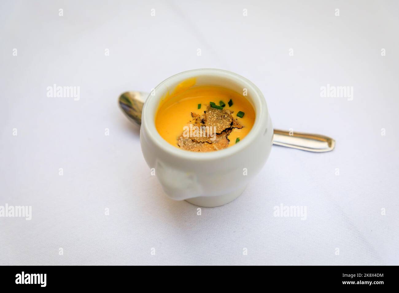 Truffle cream appetizer with a slice of a black truffle and chopped
