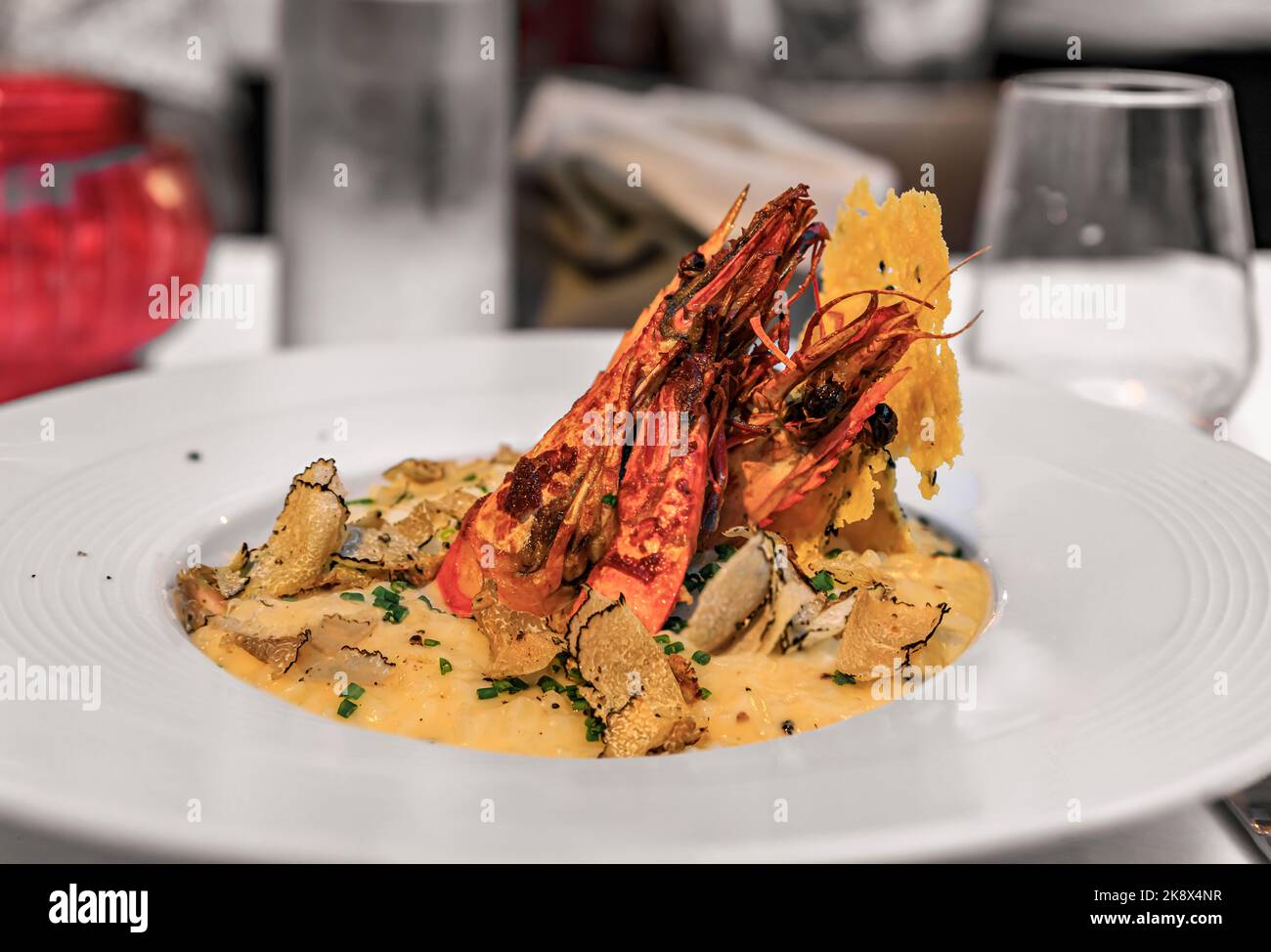 Black truffle slices shaved on top of a plate of risotto with whole