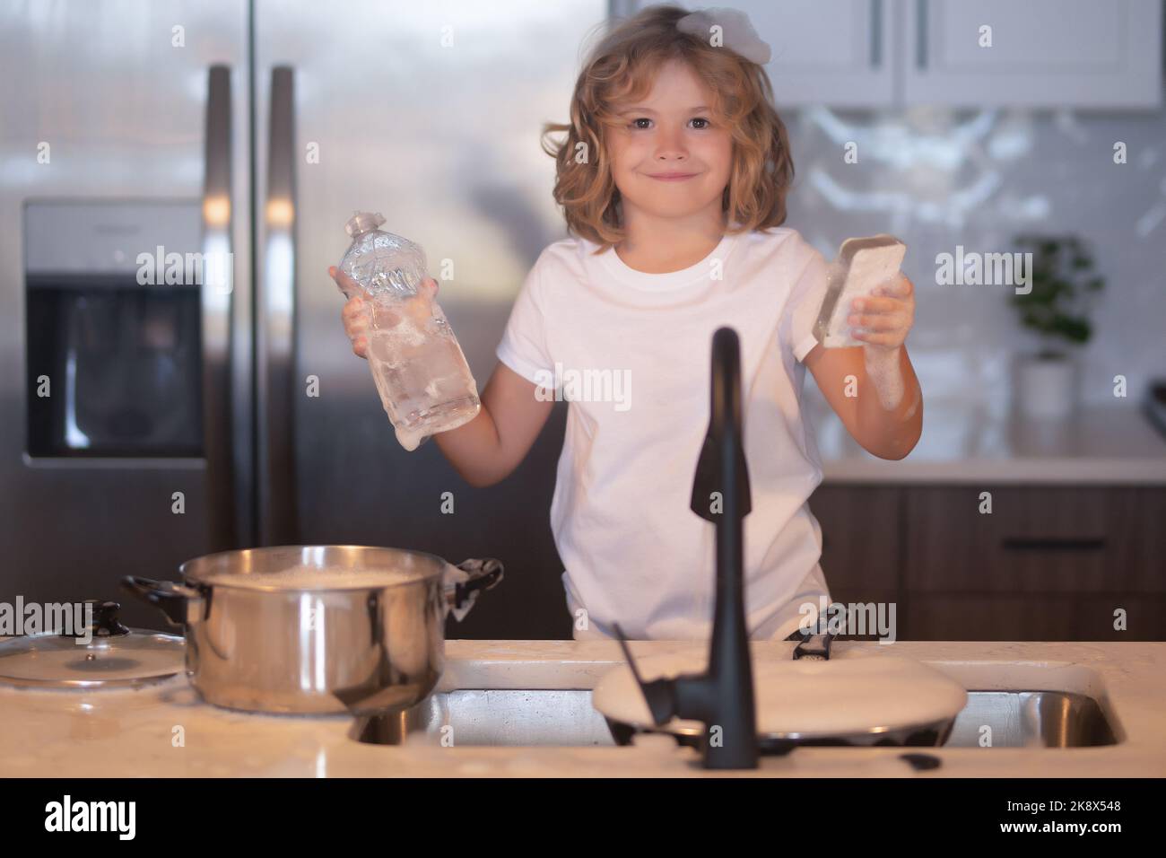 Little housekeeper. Clean washed dishes, dishwashing liquid with foam