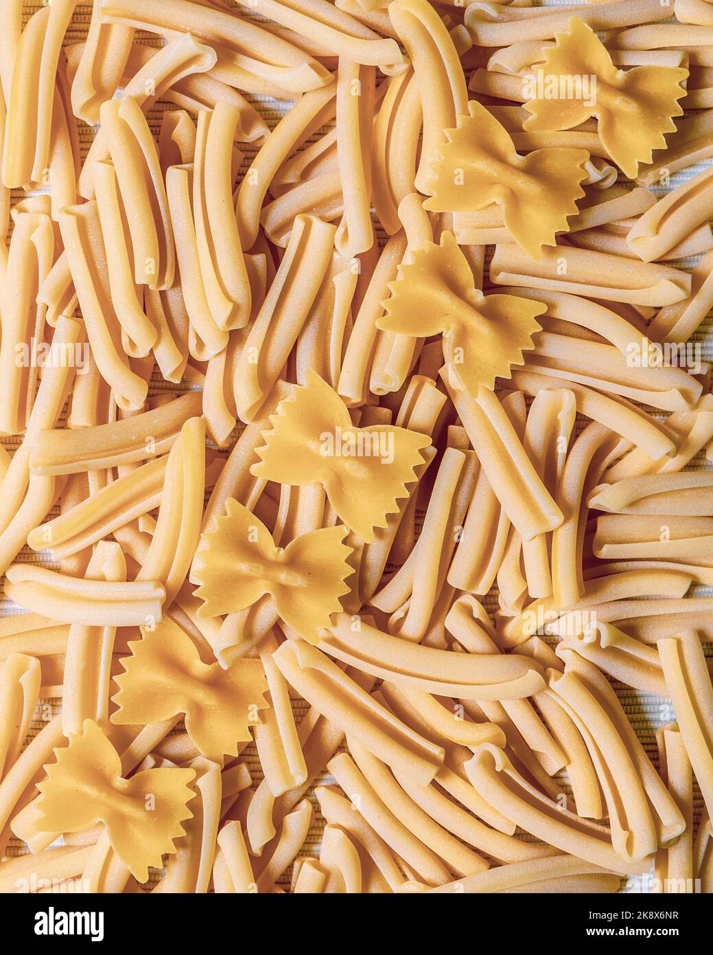 Close-up pattern of raw pasta with casarecce and farfalle on top Stock Photo