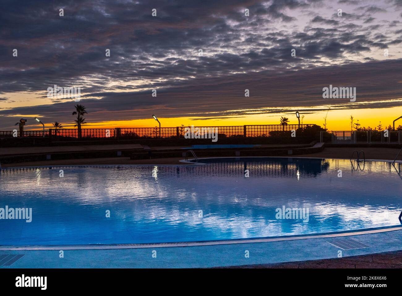 A cloudy sunrise over a swimming pool in Le Barcares, South of France. Stock Photo