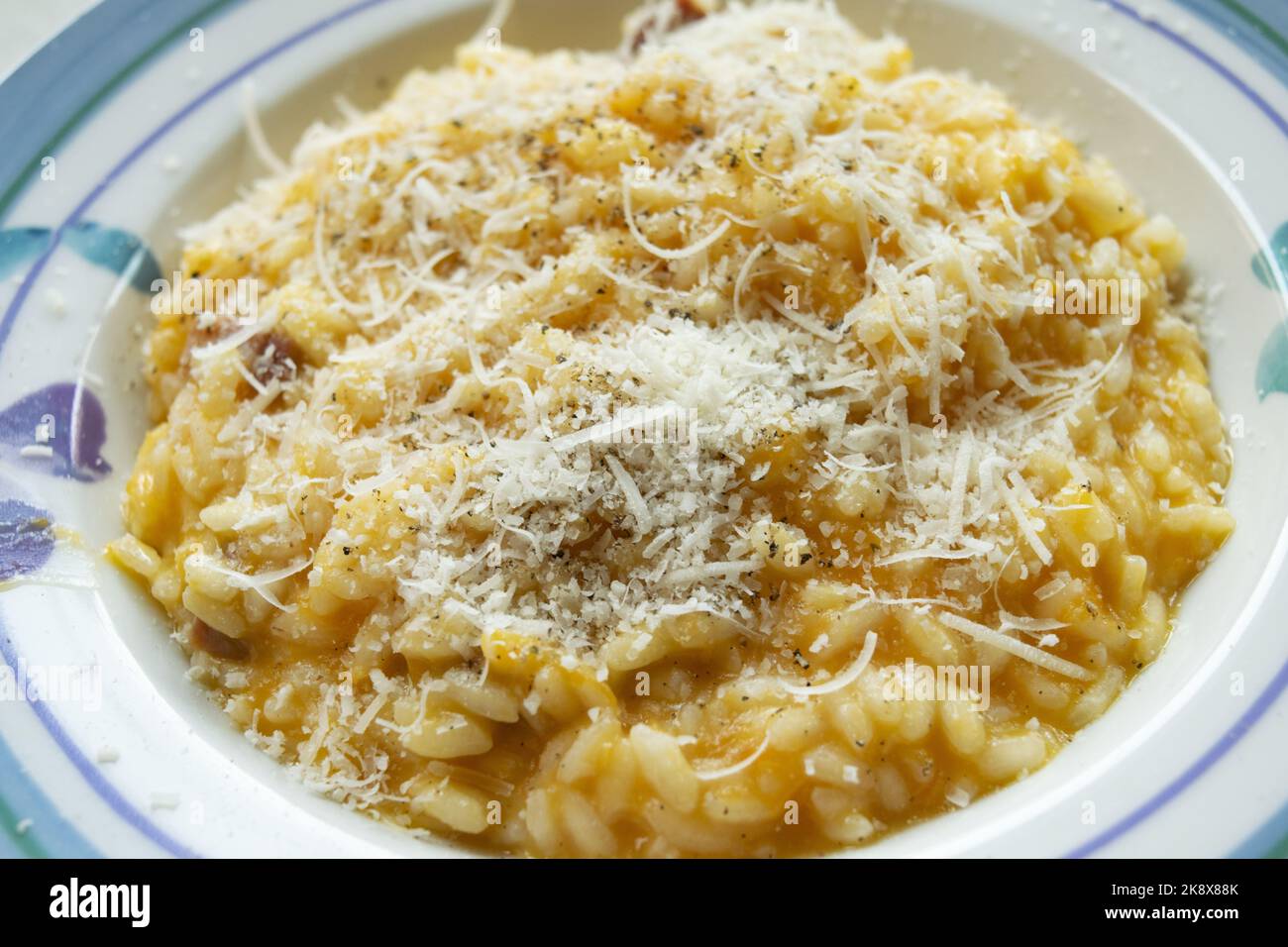 pumpkin risotto with grated parmesan in a white dish Stock Photo