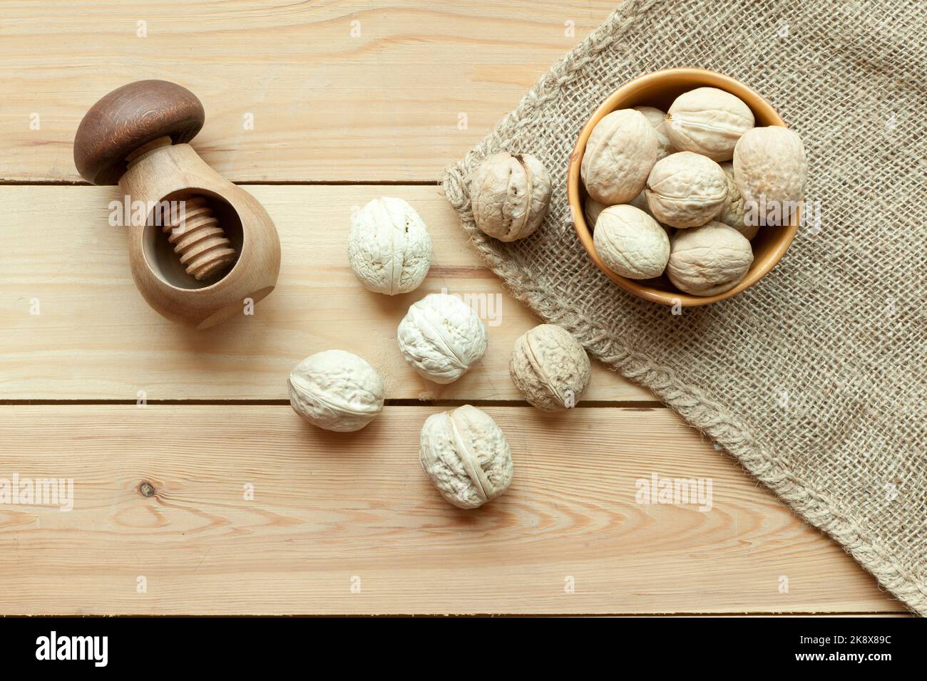 walnuts group top view on wooden table with nutcracker. Walnut kernels and whole walnuts Stock Photo