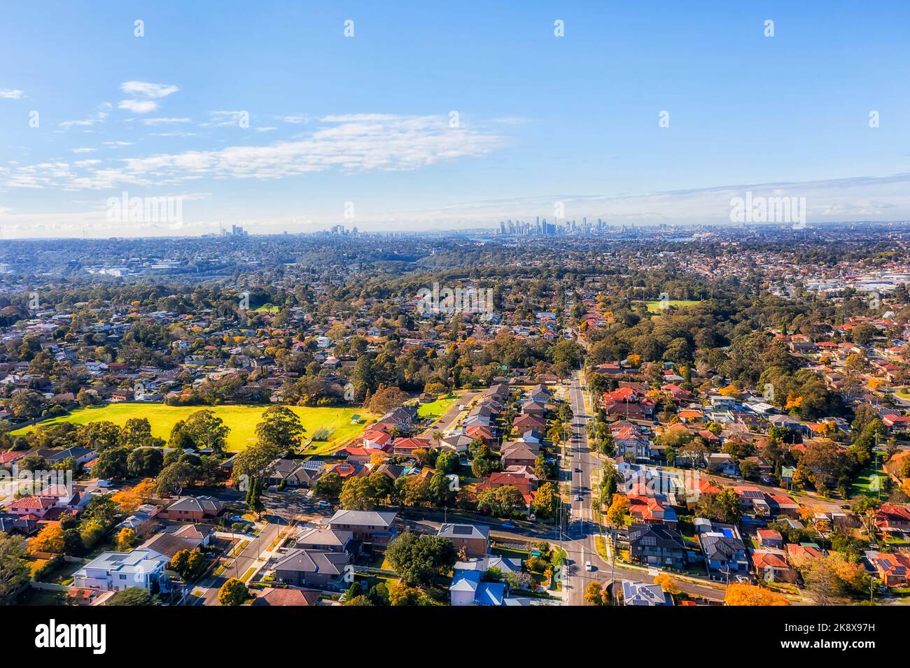 City of Ryde local residential suburbs on Sydney West in aerial cityscape view towards distant city CBD skyline. Stock Photo