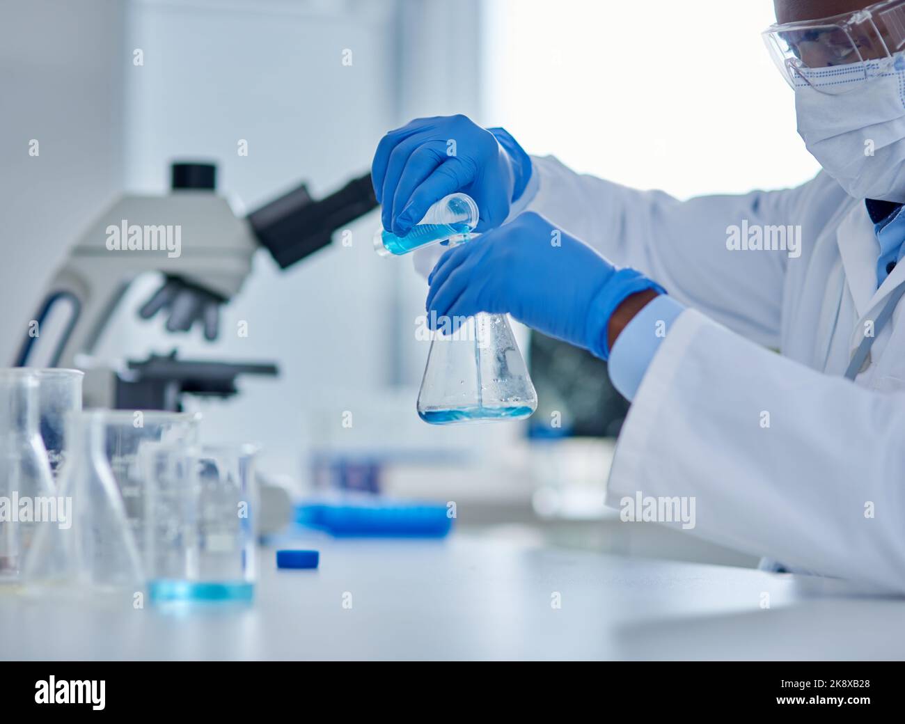 Mixing it up. an unrecognizable male scientist mixing chemicals