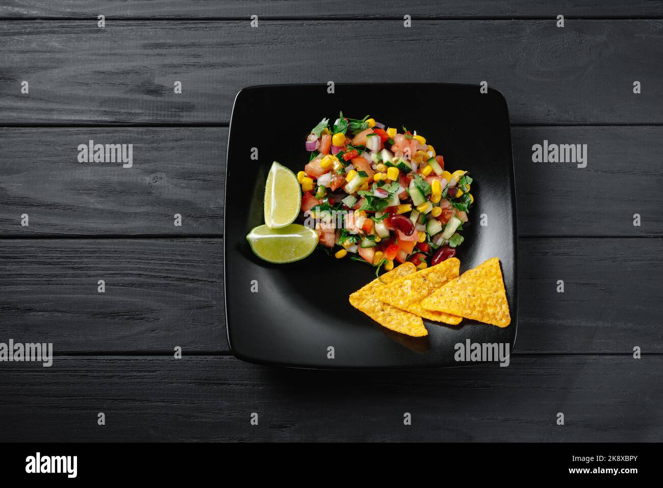 Mexican salsa dishes and ingredients on a dark wooden background with