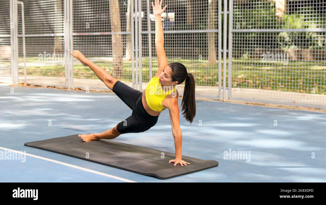 Beautiful Latin woman dressed in sports doing yoga pose outdoors. Healthcare with yoga therapy concept.  Stock Photo