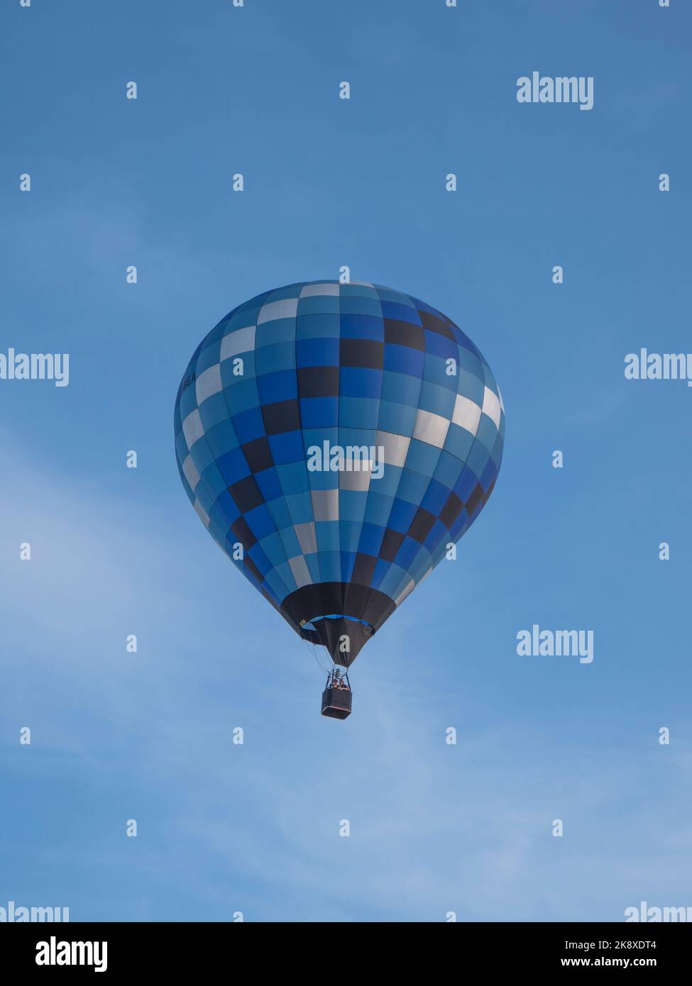 Sint Niklaas, Belgium, September 04, 2022, A hot air balloon in different color shades of gray, blue black and green with a blue sky as background Stock Photo